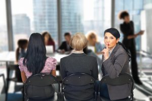 3 Professionals tijdens een overleg. Eén kijkt naar de camera